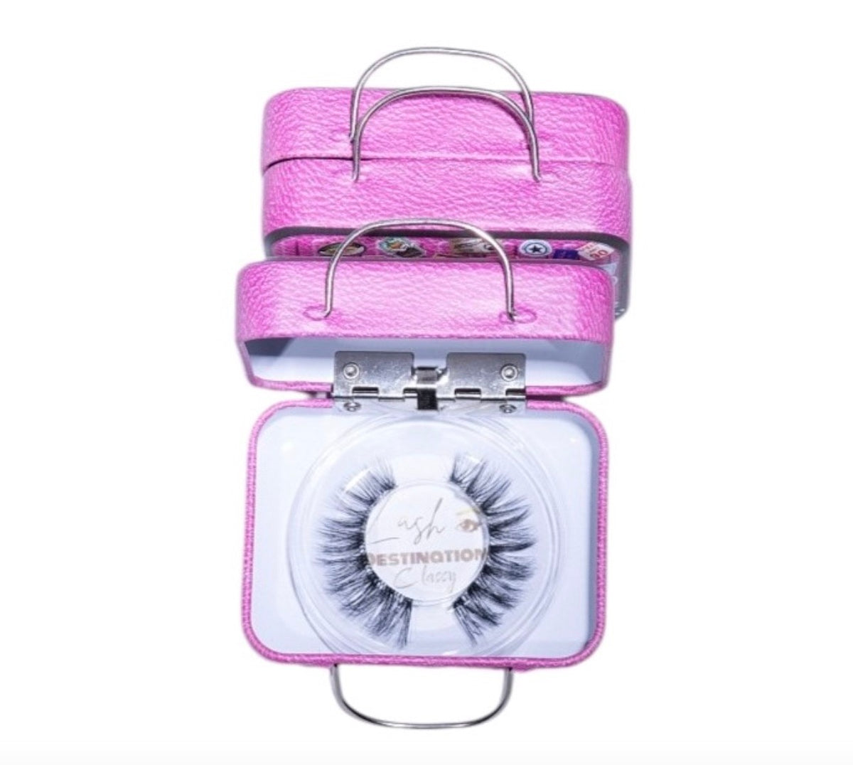 LashDestination pink miniature suitcase lash storage case with a pair of false eyelashes and a crown-shaped mirror.