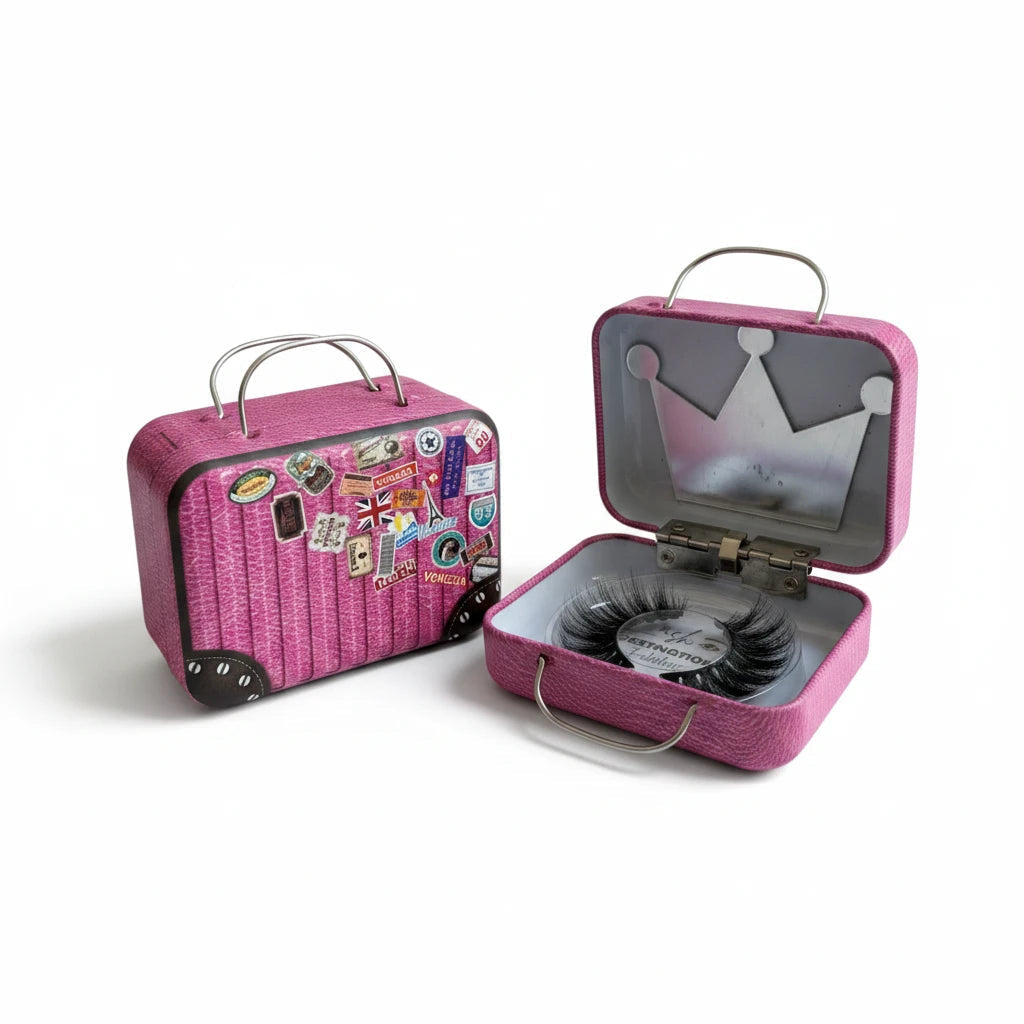 LashDestination pink miniature suitcase lash storage case with travel stickers and a crown-shaped mirror inside.